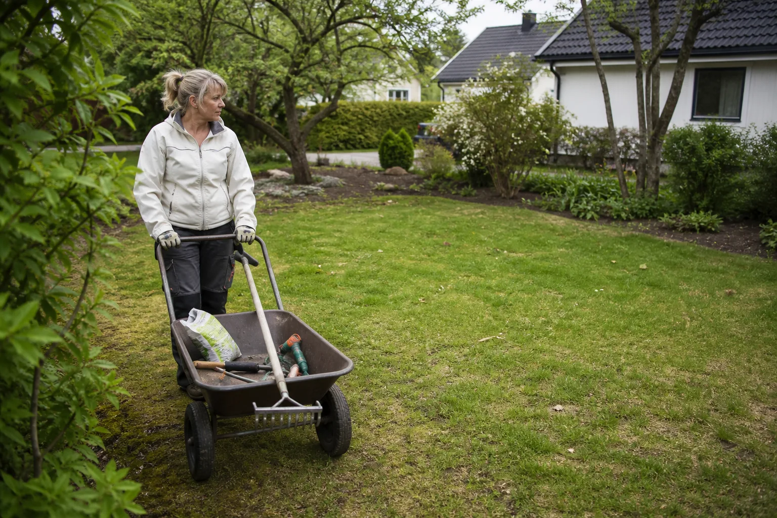 Practical lawn-care tools being moved across a spring garden